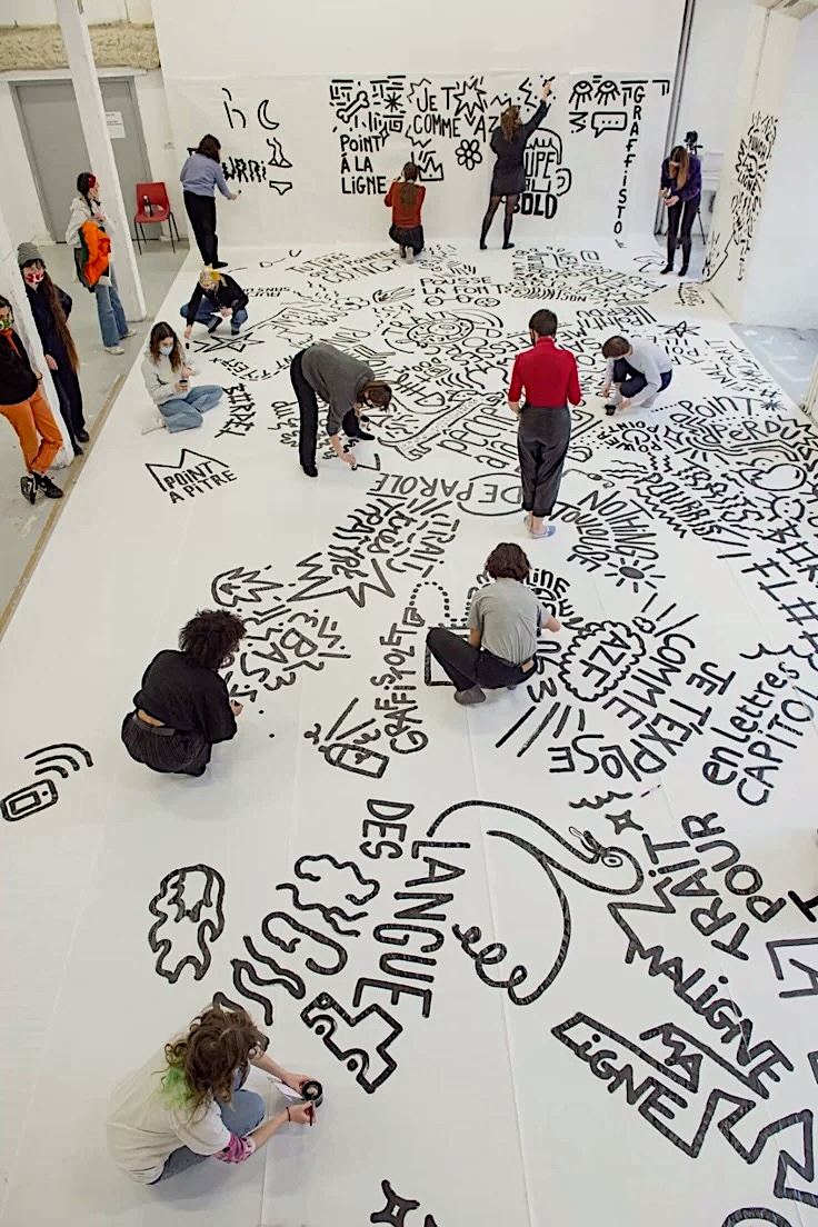 Des participants contribuent ensemble à une création collective.